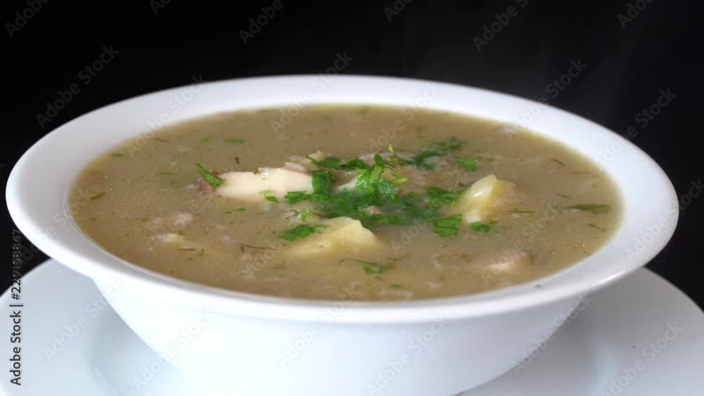 Vegetable soup with mushrooms and potatoes. Healthy food, mushrooms soup in white plate, close up, rotates Vegetable soup with mushrooms and potatoes. Healthy food, mushrooms soup in white plate, close up, rotates