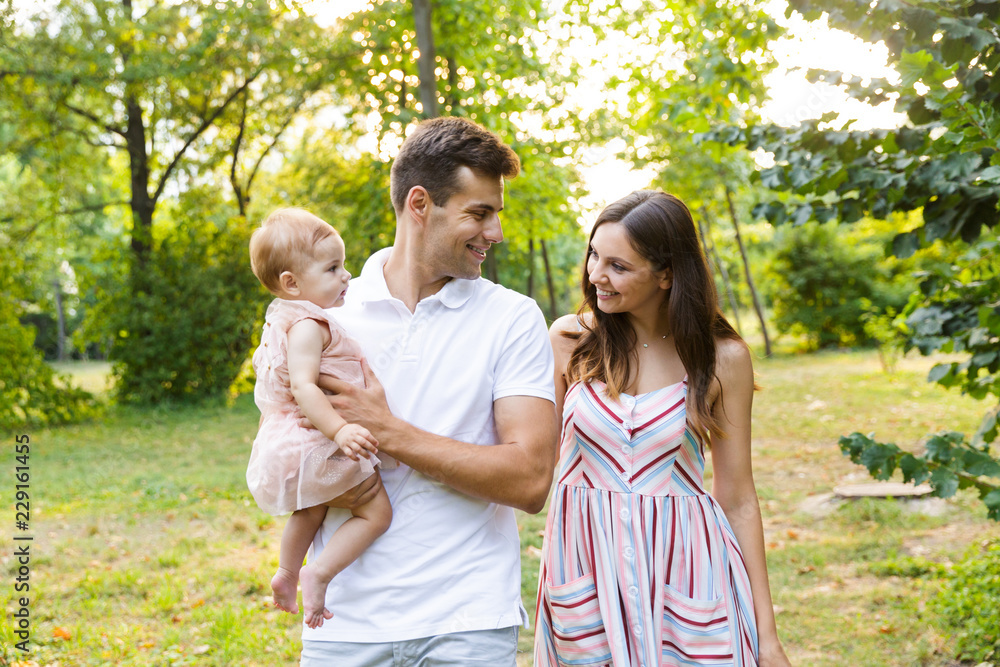 Cheerful young family with little baby girl spending time Cheerful young family with little baby girl spending time