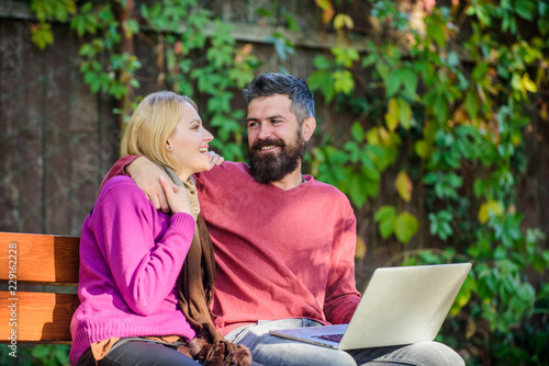 Surfing internet together. Couple with laptop sit bench in park nature background. Family surfing internet for interesting content. Internet surfing concept. Couple in love notebook consume content © be free