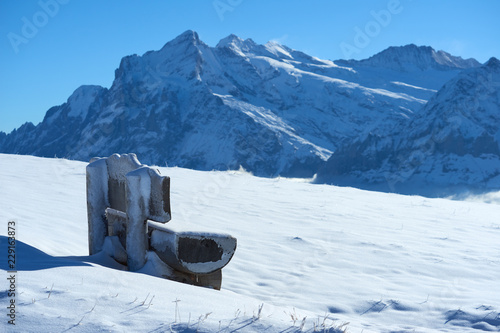 Frozen bench with mountain view in Jungfrau region in Switzerland. photo