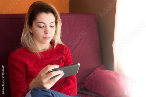 pretty young girl at home with mobile phone photo