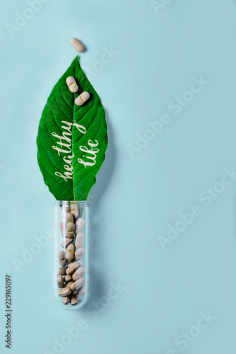 Natural vegetable pills, additive, green leaf and bottle. Healthy lifestyle and prevention of cardiovascular diseases