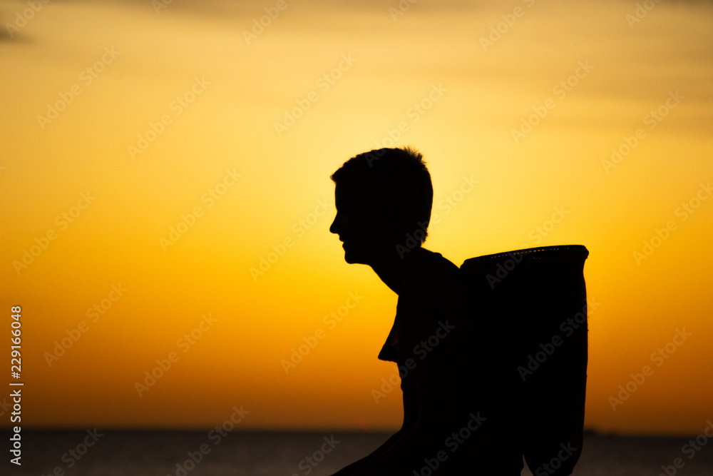 silhouettes of a family with a baby at the beach at sunset