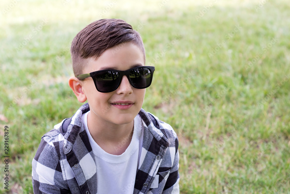 Smiling boy relaxing in park Smiling boy relaxing in park