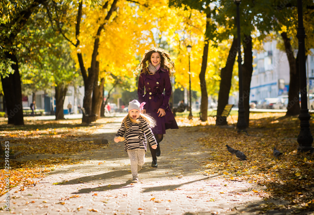 Mother and her child girl playing together on autumn walk in nature outdoors. Mother and her child girl playing together on autumn walk in nature outdoors.