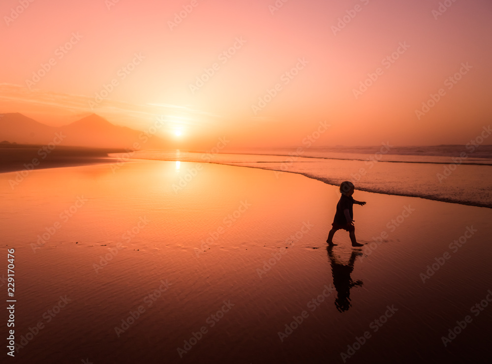 Silhouette of little boy running on Cofete beach in Fuerteventura, Canary Islands.