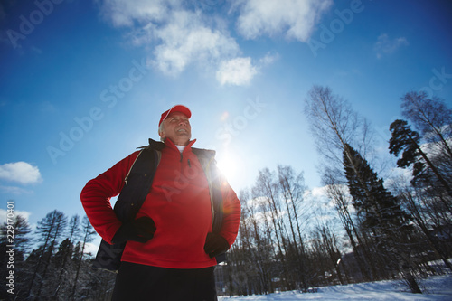 Photography Mature sportsman in activewear keeping his hands on waist while exercising in wi
