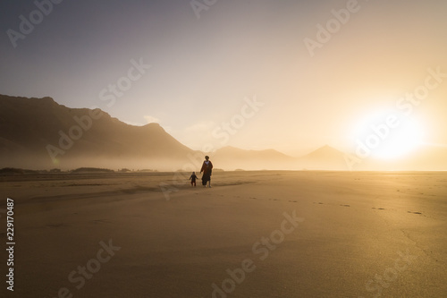 Silhouette of mother with her little child on a summer day in Fuerteventura. © paul prescott