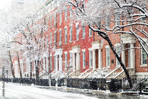 Snowy winter street scene with historic buildings along Washington Square Park in Manhattan, New York City