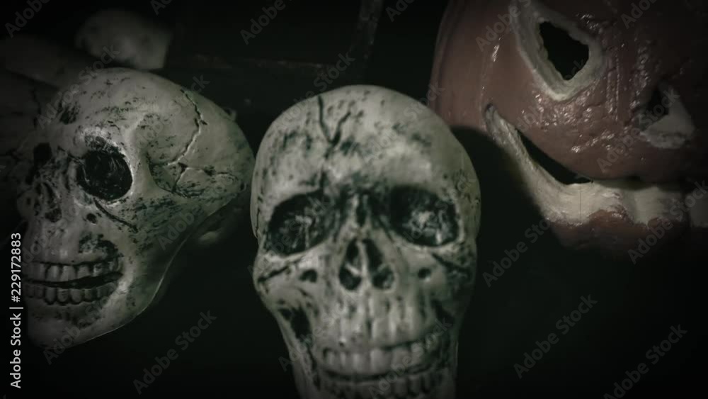 Old film look of halloween set decoration with skulls, grave and jack o'lantern Old film look of halloween set decoration with skulls, grave and jack o'lantern