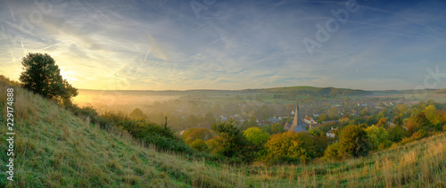 Early morning autumnal mist over East Meon village with Butser Hill and the South Downs in the background  South Downs National Park  Hampshire  UK