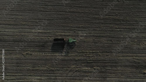 Aerial shot of Farmer with a tractor on the agricultural field sowing. tractors working on the agricultural field in Italy
