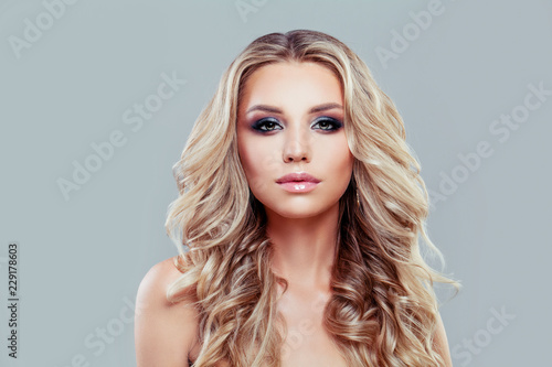 Fashion blonde woman with long wavy hairstyle and makeup