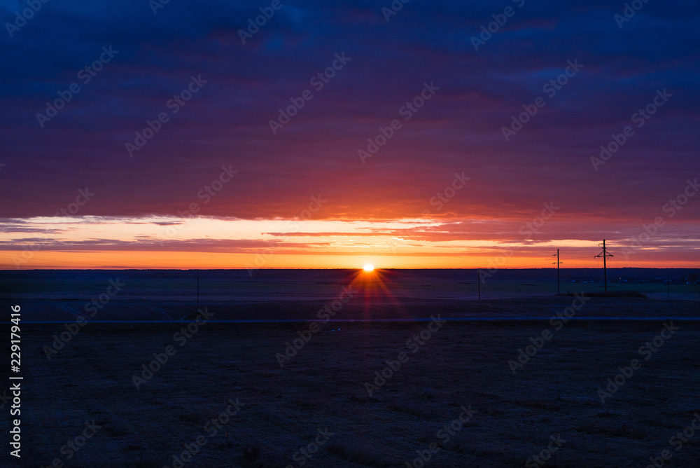 Fototapeta premium Sunrise over the field and the road