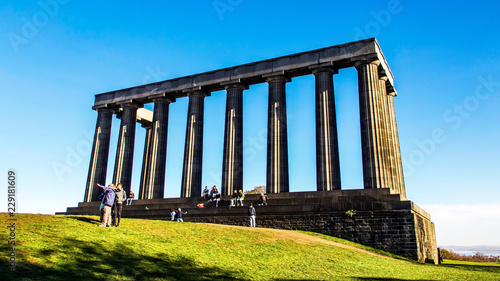 Calton Hill on a bright autumn day. Tourists on the National Monument.
