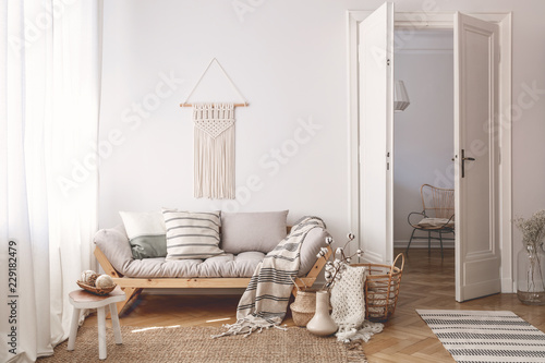 Artisan and natural decorations and accessories in a warm living room interior with wooden furniture and hardwood floor