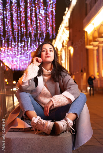 Girl resting on the street in the evening city photo