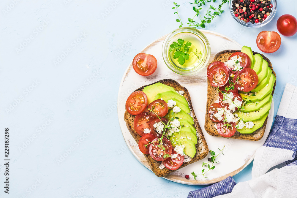 Avocado tomatoes goat cheese sandwiches. Top view, space for text. Avocado tomatoes goat cheese sandwiches. Top view, space for text.