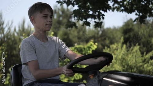 teenager driving a lawn tractor, close up