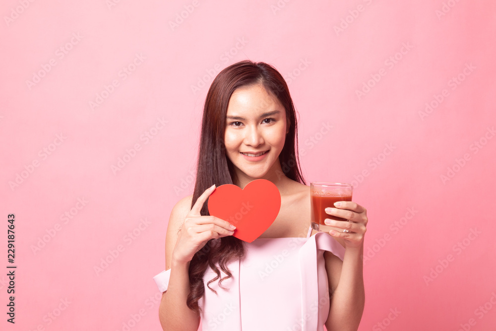Young Asian woman with tomato juice and red heart . Young Asian woman with tomato juice and red heart .