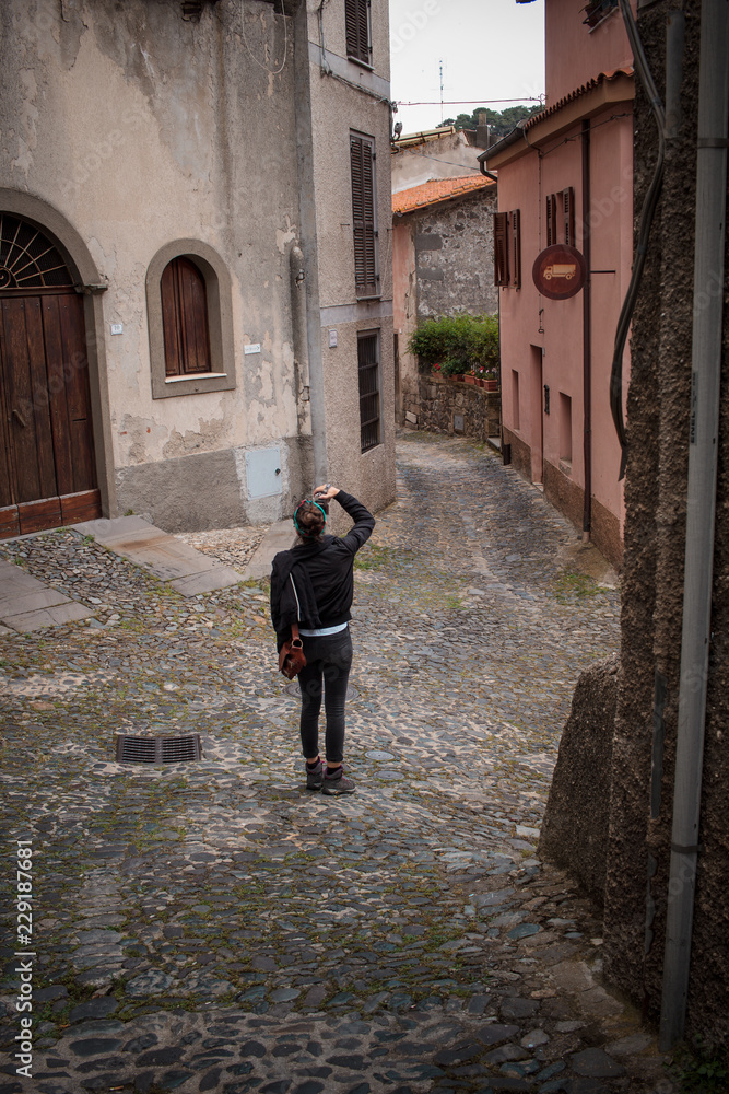 girl shooting in a beautiful old village in Sardinia, Italy. Santu Lussurgiu.