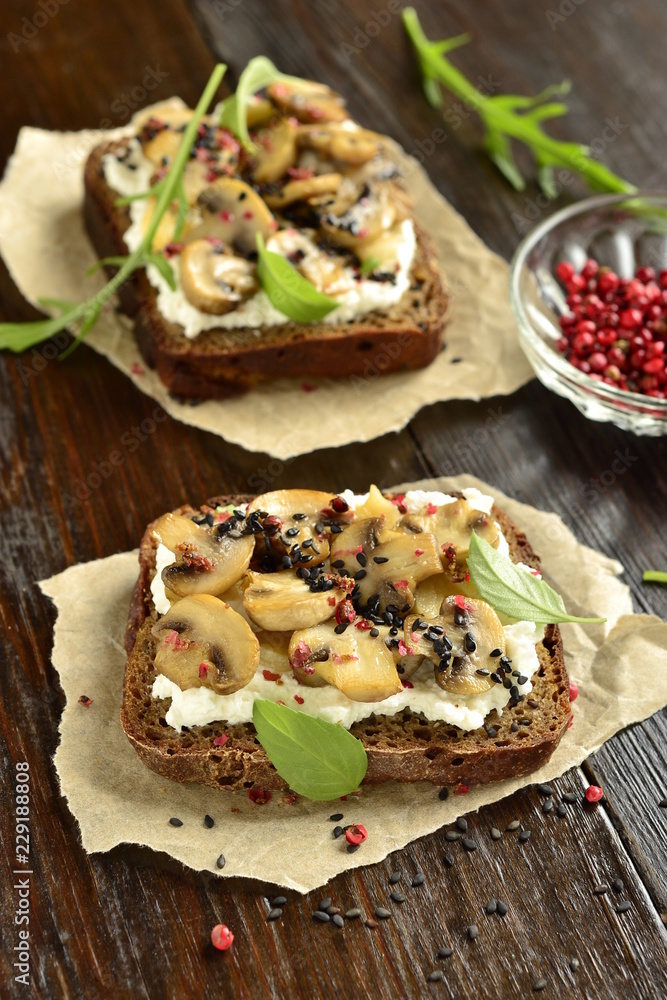 Sandwich with fried mushrooms, cream cheese, pink pepper and black sesame, vertical Sandwich with fried mushrooms, cream cheese, pink pepper and black sesame, vertical