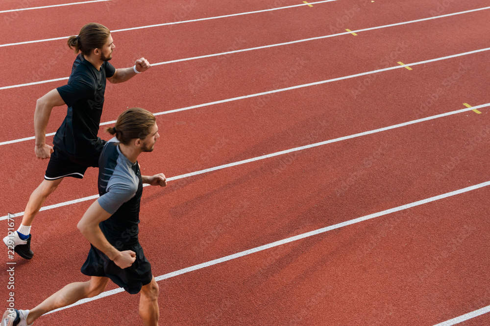 Two twins sportsmen brothers running at the stadium outdoors. Two twins sportsmen brothers running at the stadium outdoors.