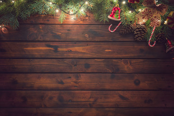 Christmas garland with ornaments on the old wooden background