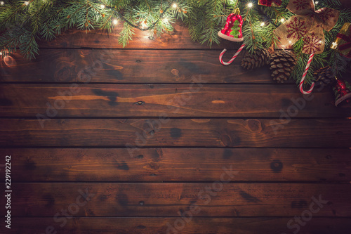 Christmas garland with ornaments on the old wooden background