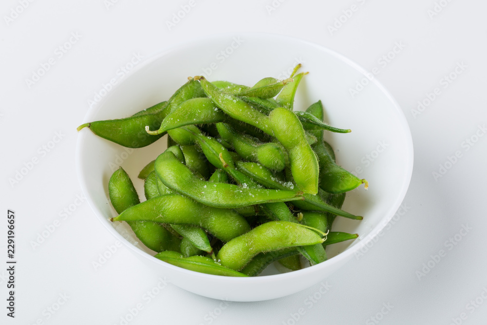 White bowl with soy beans, edamame on white bnackground White bowl with soy beans, edamame on white bnackground