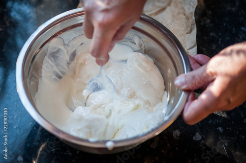 Mixing batter and sour cream for pie. Process of preparation of apple pie. Close up, soft focus. Homemade apple pie.