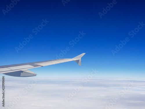 aircraft wing above the white clouds sky high for holiday travelling 