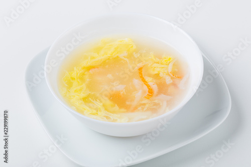 soup in the white bowl with shrimp, calamari, surimi, eggs