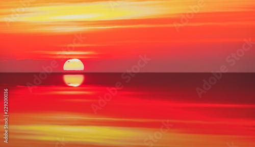 Dramatic silhouette vivid sunset sunrise reflect on sea ocean background. © sirins