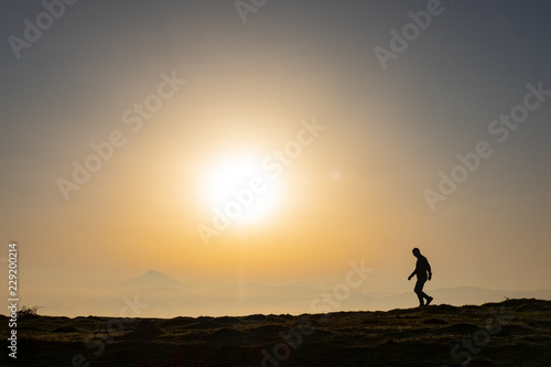 Man on the top of the hill watching wonderful scenery of colorful sunrise in mountains of Basque Country
