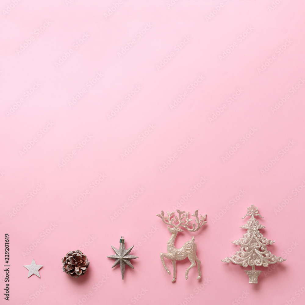 Festive silver deer, stars, fir-tree, cone on pink background with copy space. Square crop. Christmas and new year party. Minimal concept. Flat lay, top view