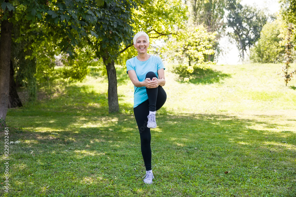 Senior woman doing streching exercise in the park Senior woman doing streching exercise in the park