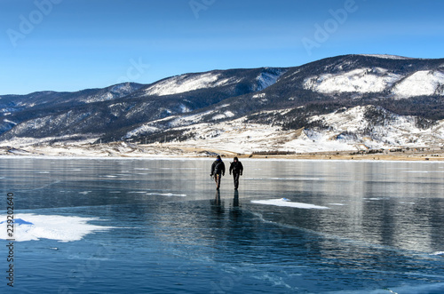 Lake Baikal is covered with ice and snow, strong cold, thick clear blue ice. Icicles hang from the rocks. Lake Baikal is a frosty winter day. Amazing place