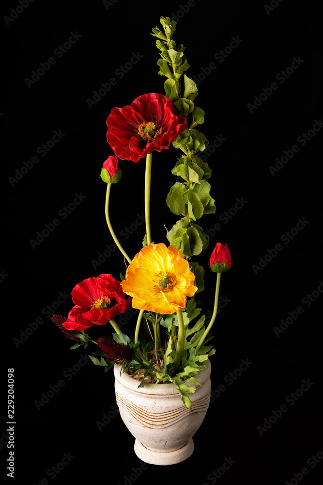 Floral arrangement from artificial poppy flowers in old ceramic flower pot. Floral arrangement from artificial poppy flowers in old ceramic flower pot.