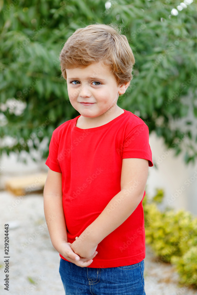Happy child with red t-shirt in the garden