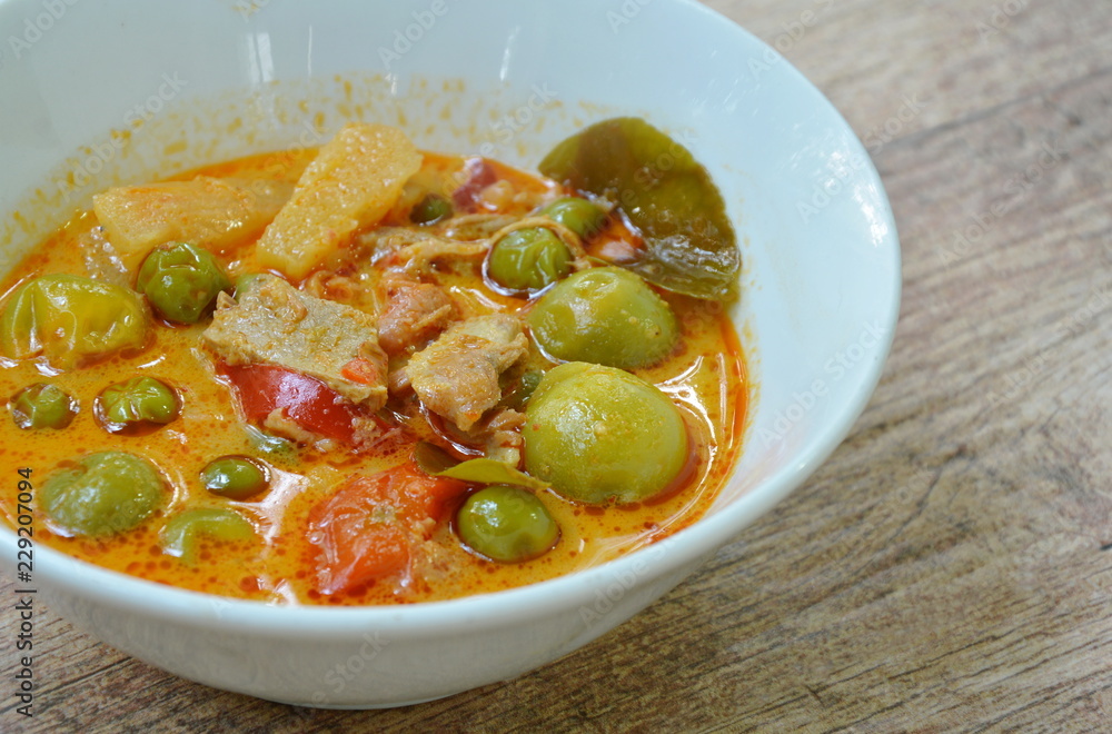 spicy boiled roasted duck meat with pineapple and eggplant in coconut milk curry on bowl