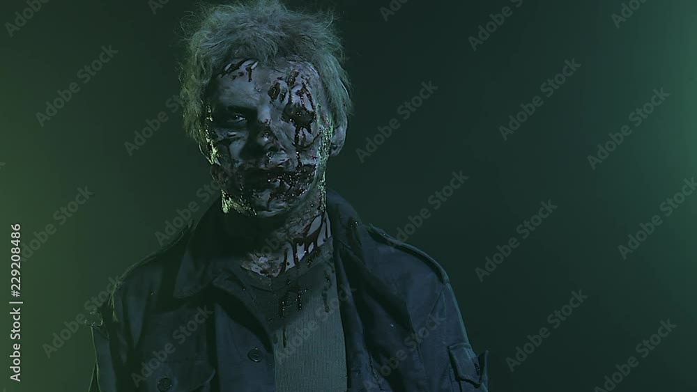 Horror zombie. Halloween party. Close-up portrait of a horrible scary zombie man in smoke. Horror zombie. Halloween party. Close-up portrait of a horrible scary zombie man in smoke.