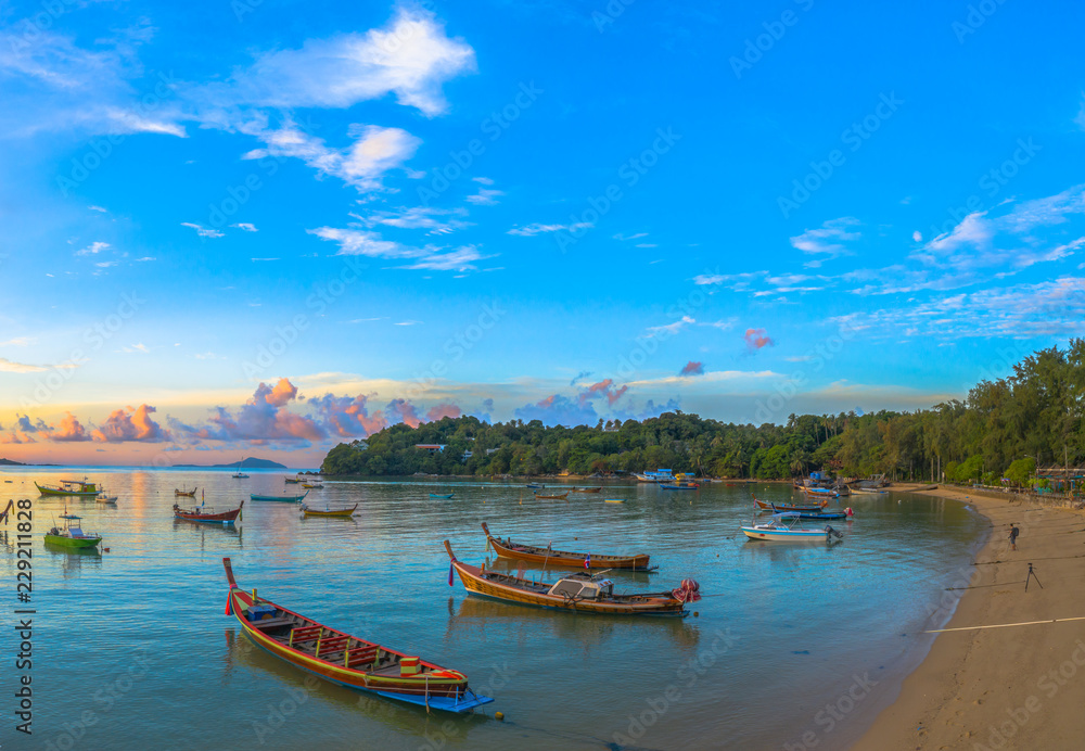 Fototapeta premium scenery aerial view sunrise above Rawai pier in golden cloudy day. a lot of fishing boats are floating in Rawai gulf