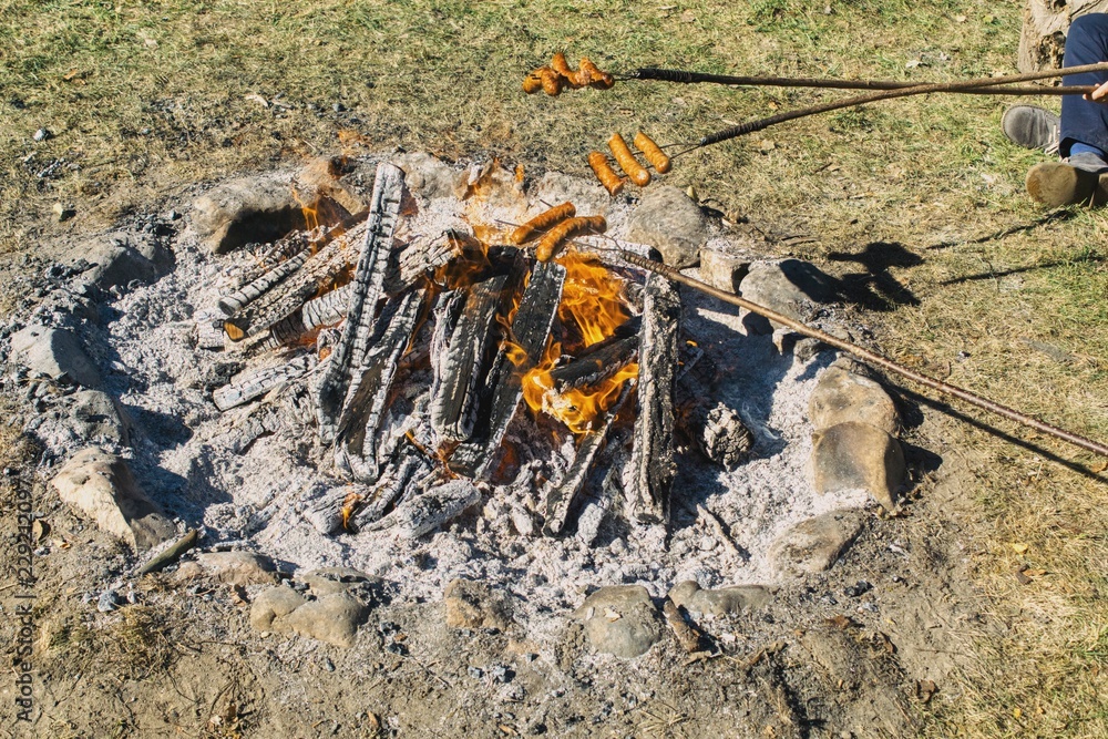 bonfire with sausages on a stick, unhealthy way of eating, burnt fats bonfire with sausages on a stick, unhealthy way of eating, burnt fats
