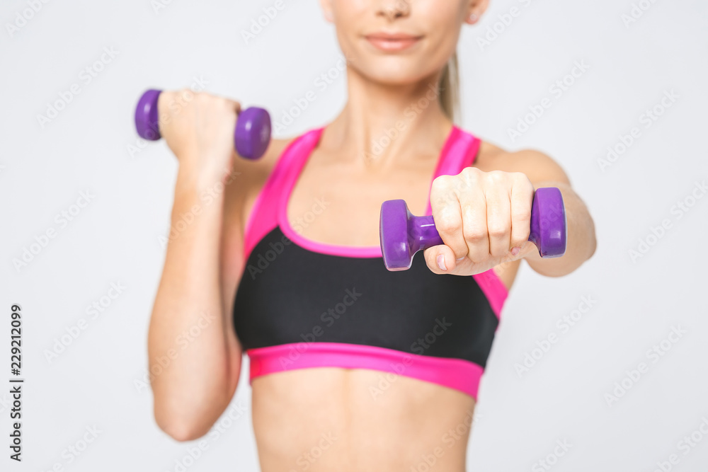 Attractive young fitness woman holding dumbell. Studio shot. Isolated over white. Attractive young fitness woman holding dumbell. Studio shot. Isolated over white.
