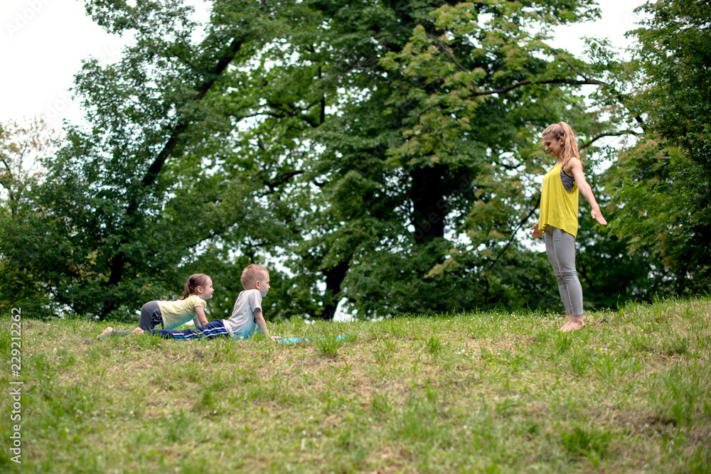 Mother and her kids doing yoga Mother and her kids doing yoga
