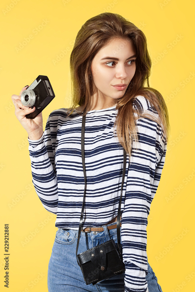 Sexy young girl with retro camera on yellow background Sexy young girl with retro camera on yellow background