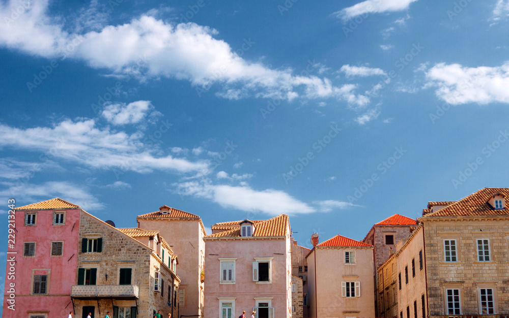 Wide angle image of colourful buildings with a bright blue sky on the background