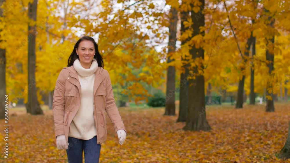 season and people concept - happy young woman walking in autumn park season and people concept - happy young woman walking in autumn park