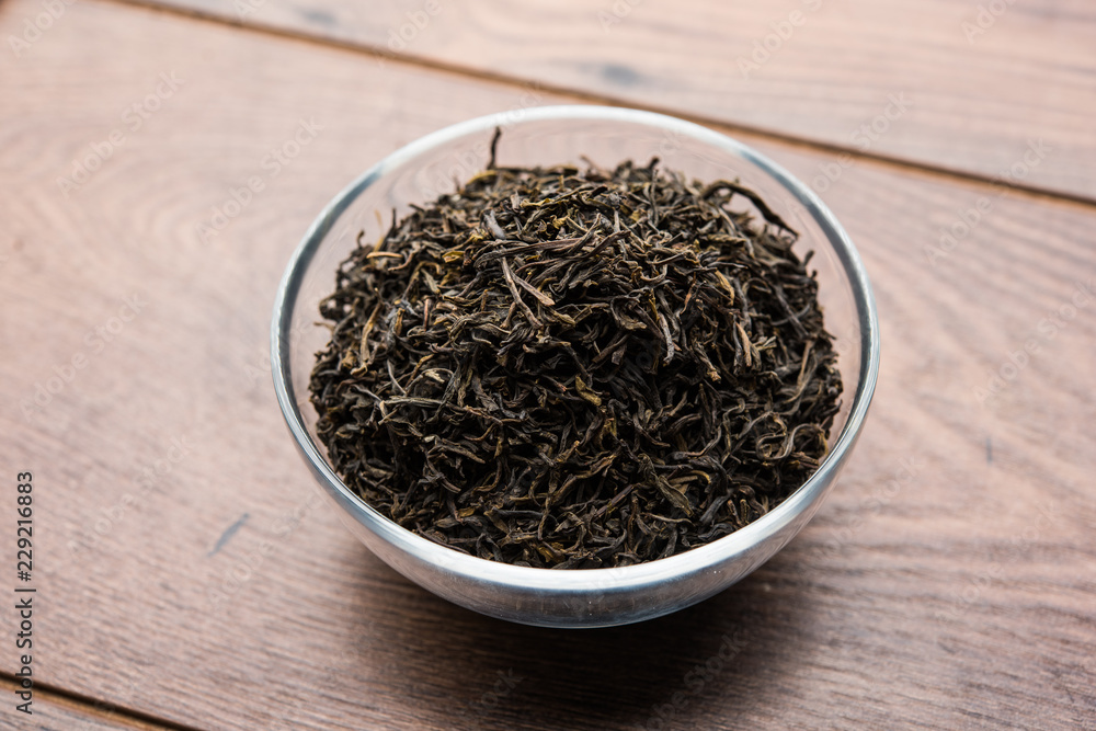 Fototapeta premium Black Tea Powder or dry dust with or without green leaf and served hot chai in a cup